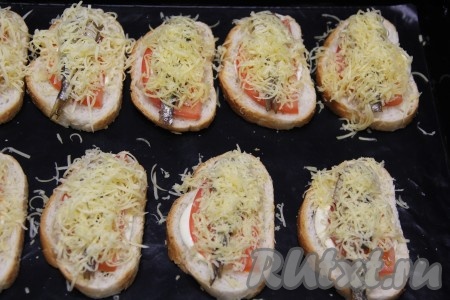 Сыр натереть на мелкой тёрке и выложить поверх шпрот. 