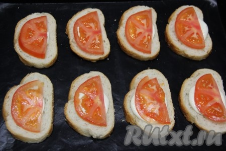 Помидор вымыть и нарезать на тонкие полукружочки. Выложить помидоры на кусочки батона, смазанные майонезом.