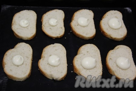 Выдавить немного майонеза на каждый кусочек батона. Слегка распределить майонез по кусочку.