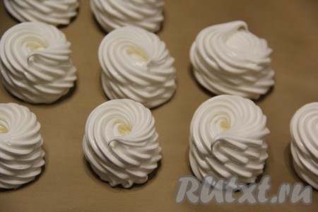 Противень застелить пергаментом. Взбитые белки переложить в кулинарный мешок с насадкой "Звезда". Отсадить белки на пергамент. Я отсадила высокими стаканчиками, то есть  в середине осталось углубление, в него будем добавлять в дальнейшем джем (или курд). Сушить взбитые белки (меренгу) в разогретой духовке при температуре 100 градусов 2-3 часа. Время даю примерное, так как всё зависит от духовки. Через два часа можно поднять меренгу и посмотреть донышко, если оно мягкое, то держим меренгу в духовке ещё час при температуре 100 градусов. Если донышко меренги постукивает, то двух часов для выпекания достаточно. Затем выключить духовку и оставить меренгу в тёплой духовке на ночь.