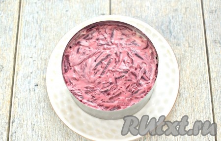 Натираем на тёрке свеклу, выкладываем её следующим слоем и покрываем майонезом.