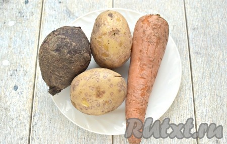 Промываем под проточной водой картофель, морковку и свеклу, чистить от кожуры их не нужно. Отвариваем картошку с морковкой до готовности (обычно с момента начала кипения воды на это требуется минут 20-25), воду в процессе варки нужно немного подсолить. Свеклу отвариваем в течение минут 40-50 после закипания воды. Отваренные овощи остужаем и очищаем от кожуры.