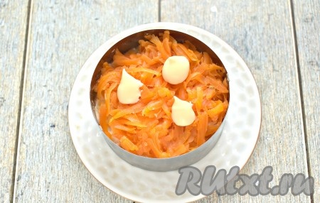 Следующим слоем раскладываем натёртую морковку, её тоже смазываем майонезом.