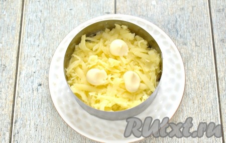 Следующим слоем равномерно выкладываем варёные картофелины, натёртые на крупной тёрке, тоже смазываем майонезом.