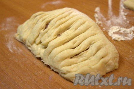 В отдельной миске взбить вилкой сырое яйцо. Края теста смазать взбитым яйцом при помощи силиконовой кисточки (это необходимо для того, чтобы верх и низ слойки лучше скрепились между собой и слоечки не "разлезались" в дальнейшем во время выпечки). Затем нарезанным краем теста накрыть край теста с начинкой и тщательно защепить вилкой (или рукой) края, формируя слойку. Аналогично сформировать все слойки с сырно-беконовой начинкой.