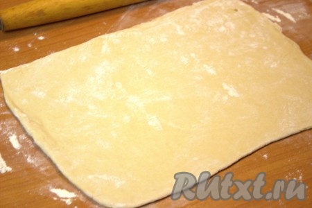 Разморозить слоёное дрожжевое тесто при комнатной температуре. Рабочую поверхность припылить мукой и выложить размороженное тесто. У меня слоёное тесто было из двух квадратных пластов. Каждый пласт раскатать в одном направлении до толщины 2-3 мм. Получатся два больших прямоугольника из теста.