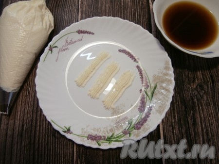 Поместить творожную массу в кондитерский мешок с любой насадкой, какая вам нравится. Я вначале взяла насадку, которой оформляют борта торта, а потом украшала десерт с помощью насадки "Звёздочка". Начинаем собирать наш мини-тирамису. На дно тарелки отсадить буквально три небольших полоски творожной массы из кондитерского мешка.