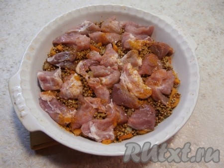 Содержимое сковороды переложить в форму для запекания (у меня диаметр формы 26 см). Кусочки свинины посолить и приправить приправой для мяса. На гречку с овощами выложить кусочки мяса.