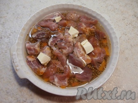 Влить воду комнатной температуры и добавить кусочки сливочного масла.