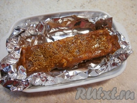 Оставить грудинку на 1 час при комнатной температуре. Затем сверху смазать её французской горчицей, поместить в любую подходящую форму (или на противень), подвернув края фольги вовнутрь, сформировав "лодочку" из фольги. Грудинка должна остаться открытой.