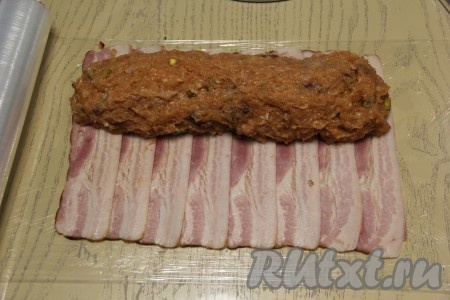 Выложить куриный фарша на край пласта из бекона в виде колбаски.