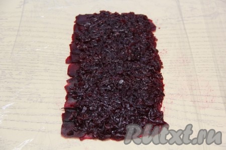 Остатки свеклы натереть на мелкой тёрке. Ингредиенты в дальнейшем будем выкладывать, немного отступив от одного из длинных краёв прямоугольника. Итак, немного отступив от одного из длинных краёв прямоугольника, выложить натёртую свеклу.