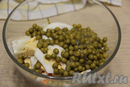 В салат из копчёной курицы, моркови, огурцов и яиц выложить пропущенный через пресс чеснок и консервированный горошек без жидкости, посолить по вкусу.