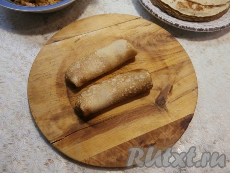 Свернуть блины конвертиками или трубочками, подгибая края вовнутрь.