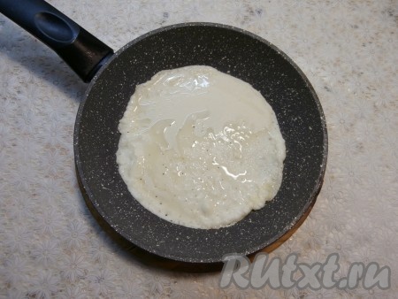 Пока начинка остывает, испечём блинчики. Перед жаркой первого блина хорошо раскалённую сковороду (у меня сковорода диаметром 20 см) желательно смазать растительным маслом. Налить на сковороду половник теста, равномерно распределяя его, жарить блин на огне чуть выше среднего до румяности.
