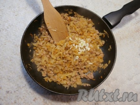 В сковороду выложить измельчённый чеснок, перемешать и протушить ещё 5-7 минут под крышкой (до полной готовности капусты), убрать с огня, дать остыть и капустно-мясная начинка для блинчиков готова.