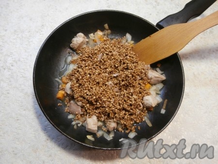 Обжарить кусочки свинины с овощами в течение 4-5 минут, периодически помешивая. Затем добавить в сковороду промытую гречневую крупу.