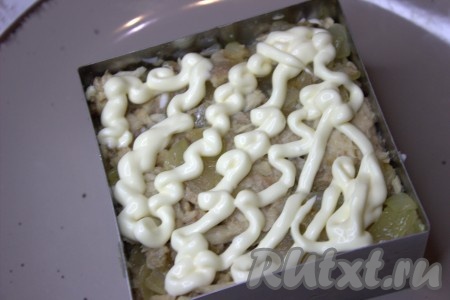 Выложить следующим слоем горбушу, смешанную с обжаренным луком, слегка утрамбовать, нанести майонез.