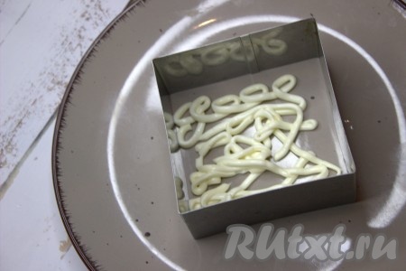 Этот рыбный салат нужно выкладывать слоями, удобнее всего это делать с помощью кулинарной формы. На плоскую тарелку поставить кулинарную форму, с помощью, которой будет формироваться салат. Внутри формы сделать майонезную сеточку.