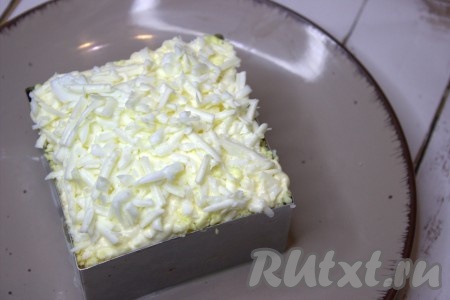 Поверх желтков выложить оставшуюся часть смеси белков и сыра, немного утрамбовать и прямо в кулинарной форме убрать салат в холодильник на 20-30 минут.