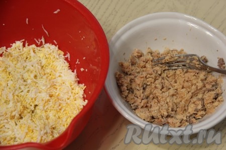 Консервированную горбушу из банки переложить в небольшую миску, если жидкости в баночке много, её лучше слить (она нам не понадобится). Крупные косточки из рыбы нужно удалить, а затем размять горбушу вилкой. В другую тарелку натереть на мелкой тёрке яйца.