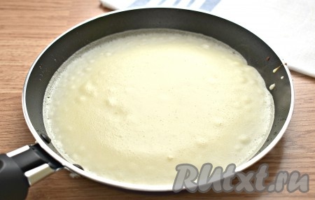 Поверхность сковороды для выпечки блинов (я жарила на сковороде диаметром 18 см) смазываем маслом и хорошо прогреваем. Нагрев плиты должен быть чуть выше среднего. Зачерпываем половником блинное тесто (примерно, половину объёма обычной поварёшки) и распределяем его по разогретой поверхности сковороды. Жарим блинчик с одной стороны, примерно, 45 секунд (до подрумянивания), затем переворачиваем и жарим блин ещё секунд 30-35, затем перекладываем на тарелку. Постепенно жарим все блинчики (всего у меня получилось 13 штук). Периодически блинное тесто в миске нужно перемешивать. Сковороду смазывать маслом нужно только при необходимости.