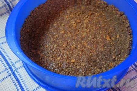 Основу для торта выложить по разъёмной форме, сформировав бортики. Убрать на 10 минут в холодильник.