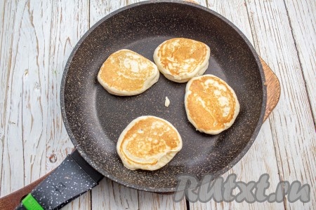 Для жарки оладий лучше выбрать сковороду с хорошим антипригарным покрытием, тогда не нужно будет её смазывать маслом. Если не уверены в своей сковороде, то смазывайте её маслом перед выпечкой каждой партии оладушек. Хорошо раскалите сковороду, выкладывайте по столовой ложке теста и жарьте на среднем огне с одной стороны 1-2 минуты (до подрумянивания), затем переверните оладушки и жарьте ещё с минутку под крышкой. Готовые оладьи переложите на тарелку. Постепенно испеките все оладушки.