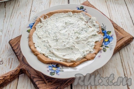 На остывший печёночный блин выложите ровным слоем часть творожной начинки.