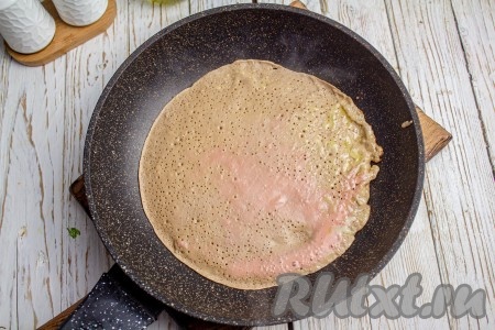 Как только тесто замешано, нужно сразу приступать к выпечке блинчиков. Печёночные блины я жарю без масла на антипригарной сковороде, предварительно хорошо раскалив её (но при желании перед выпечкой первого печёночного блина можно немного смазать сковородку маслом). Вливаю чуть меньше половника теста и распределяю его по всему дну сковороды. Выпекаю с одной стороны с минутку при среднем нагреве плиты.