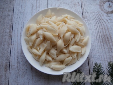 Короткие макаронные изделия выложить в кастрюлю с кипящей водой, немного подсолить и отварить до готовности (время варки смотрите на инструкции на упаковке, обычно на отваривание требуется 7-9 минут, но в этом рецепте допускается, чтобы макароны были чуть переварены), откинуть на дуршлаг, промыть холодной водой. Для этого блюда понадобится 300 грамм варёных макарон.