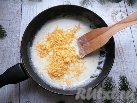 Смесь посолить, добавить 70 грамм сыра, натёртого на мелкой тёрке. Перемешивать сырно-сливочный соус лопаткой на умеренном огне до расплавления сыра и однородной консистенции.