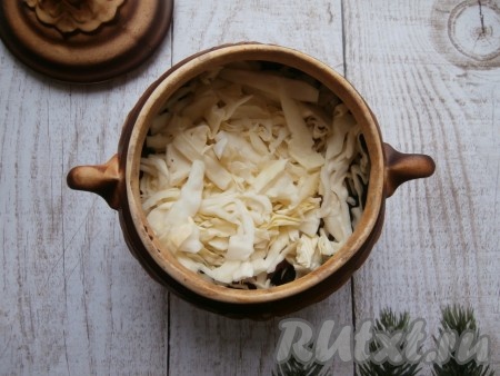 Поверх свинины выложить капусту, чуть посолить.