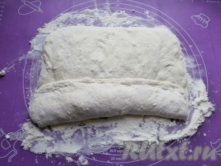 Посыпая тесто мукой, растянуть его в прямоугольник и быстро начать сворачивать в рулет.