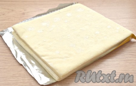 Заранее достаём слоёное тесто из морозилки и размораживаем его при комнатной температуре. Пласты теста должны стать мягкими. На разморозку теста мне потребовалось почти 1 час 20 минут.