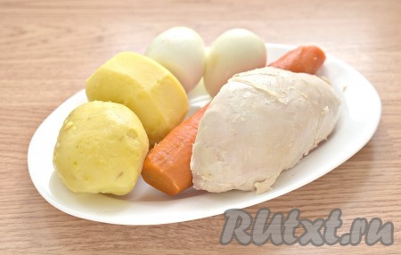Отвариваем куриное филе в подсоленной воде (варим после закипания 30 минут), затем остужаем. Промываем картофель и морковь, очищать корнеплоды не нужно. Отвариваем картофель после закипания воды в течение 20-25 минут, морковь - около 30 минут. Отвариваем яйца в течение 10 минут после закипания. Остужаем картошку, морковку и яйца, очищаем.