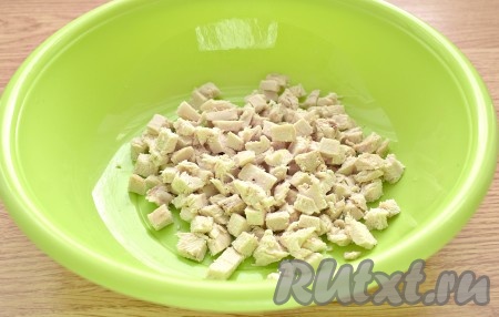 Отваренное филе нарезаем на маленькие кубики и перекладываем в глубокую миску.
