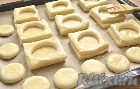 Заготовки с отверстиями помещаем на смазанные основания. Также смазываем их яйцом. Оставшиеся кружочки я тоже отправила на противень.