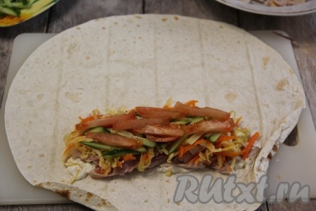 Поверх выложить часть нарезанного огурца и помидора.