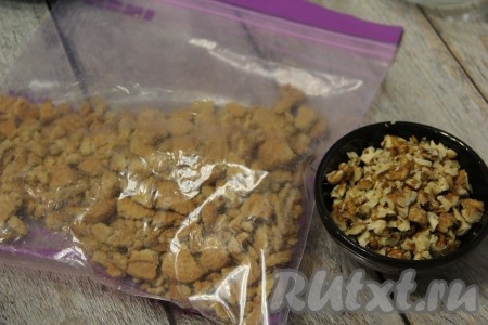 Орехи (у меня - грецкие) крупно нарезать ножом. Печенье поместить в пакет и измельчить скалкой на кусочки (до мелкой крошки измельчать не нужно). 