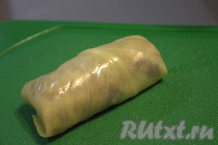 Свернуть лист капусты с начинкой рулетиком, подгибая края во внутрь. Таким образом сформировать все голубцы (у меня получилось 10 штук) с начинкой из фарша, грибов и риса.