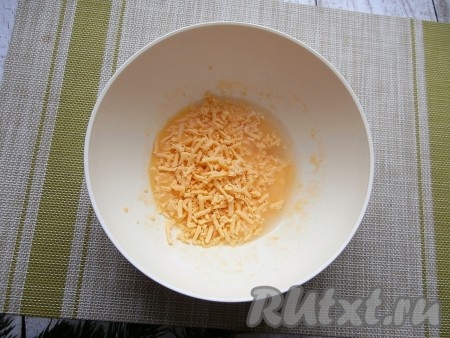 Влить воду, тщательно перемешать венчиком (или вилкой), добавить натёртый на средней (или мелкой) тёрке сыр.