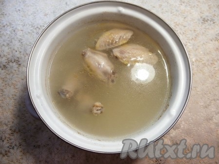 Части курицы промыть, выложить в кастрюлю, влить 3-3,5 литра воды, поставить на огонь. После закипания посолить бульон и варить на небольшом огне до готовности мяса (примерно, минут 20). После того как мясо сварится, по желанию, его можно отделить от костей и вернуть в кастрюлю, я отделять от косточек не стала, так как готовила с разрезанными на части куриными крылышками. Если готовите постный вариант рассольника с булгуром, тогда этап варки мяса пропустите.