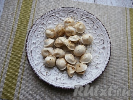 Пельмени достать, добавить оставшееся сливочное масло, перемешать.