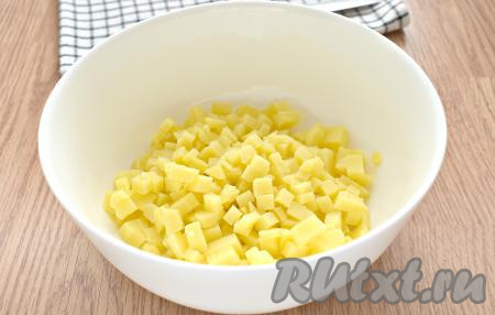 Ингредиенты для салата "Московский" нужно нарезать на кубики, приблизительно, одинакового размера. ​​​​​​Нарезаем картошку на мелкие кубики, сразу перекладываем в достаточно глубокий салатник.