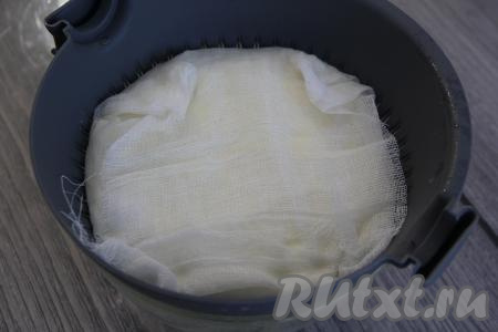 Затем аккуратно перевернуть массу с помощью тарелки и вернуть обратно в форму (или дуршлаг). Накрыть творожную массу свисающими краями марли, сверху накрыть тарелкой, поверх которой поставить не очень тяжёлый гнёт (например, литровую банку, наполненную водой до половины), чтобы избавиться от лишней жидкости в творожной массе. Поставить всю эту конструкцию в холодильник на два дня. Через некоторое время нужно хорошо прижать сырную массу, чтобы более плотно утрамбовать сыр, поэтому гнёт поставьте более тяжёлый.