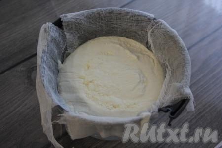 Приготовить специальную форму для сыра, она чем-то напоминает дуршлаг (в ней есть отверстия для сливания лишней влаги). Если нет такой формы, то можно взять дуршлаг. Застелить в несколько слоёв форму для сыра марлей (или широким бинтом), края марли должны свисать с краёв формы. Застеленную форму поставить в глубокую тарелку (или в кастрюлю), туда будет в дальнейшем стекать жидкость из творожной массы. Готовую творожную массу переложить из кастрюли в форму и дать 15 минут постоять. 