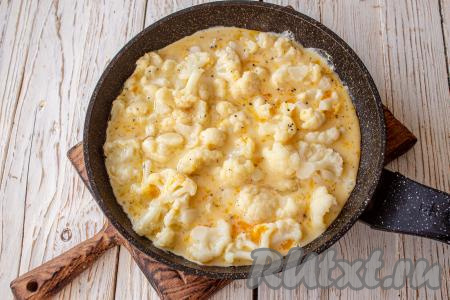 Залейте яичной смесью. Убавьте нагрев до минимального и готовьте омлет с цветной капустой под крышкой 7-10 минут.&nbsp;