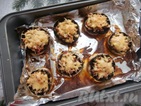 Запекать шляпки шампиньонов 15-20 минут в разогретой духовке при температуре 180 градусов (до подрумянивания сыра).