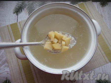 В кастрюлю с закипевшей водой, выложить кусочки картошки и рис, посолить по вкусу, дать супу закипеть, а затем варить на слабом огне 20-25 минут.